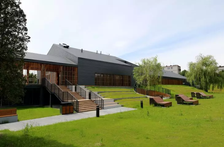 The pool surrounds a large green area