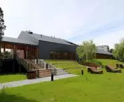 The pool surrounds a large green area