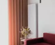 koralowa sofa i designerska lampa projektu Le Corbusiera