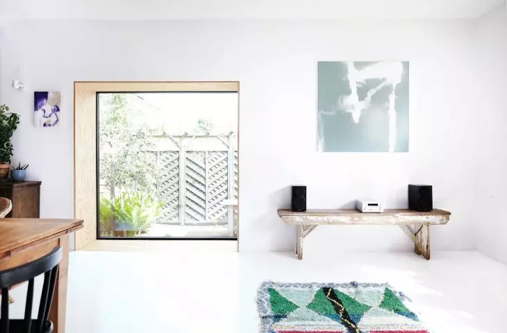 large glazing surrounded by a deep wooden frame adds a modern touch to the interior