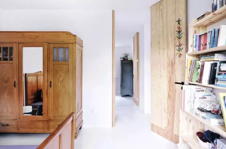 stylish three-door wooden closet with mirror complements the minimalist interior