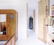 stylish three-door wooden closet with mirror complements the minimalist interior