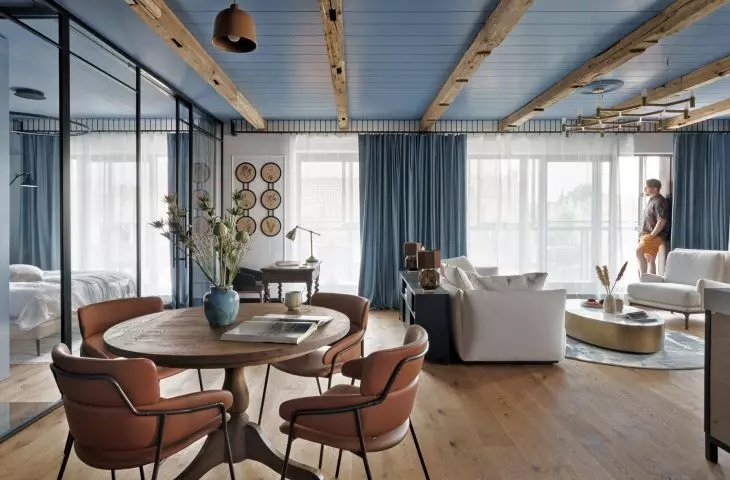 The bedroom is separated from the living room by a glass window