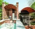 Wall House ukończono w 2000 roku, dekadę po pierwszym projekcie architetki w Auroville — Hut Petite Ferme