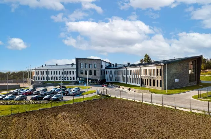 Zespół szkolno-przedszkolny w Przybysławicach, elewacja pokryta skośnymi, drewnianymi belkami 
