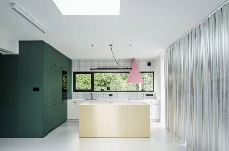 A kitchen dominated by green, gold and pink