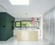 A kitchen dominated by green, gold and pink