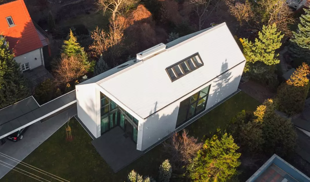 House with a jam in Wroclaw, a project of the Studio of Architecture Glowacki PAG, on the roof and elevation used white small-format tiles CEDRAL 