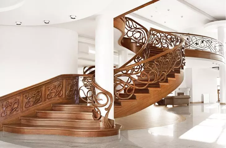 Schody o konstrukcji betonowej z balustradą ręcznie rzeźbioną, drewno bodo. Realizacja w salonie ekspozycyjnym.
