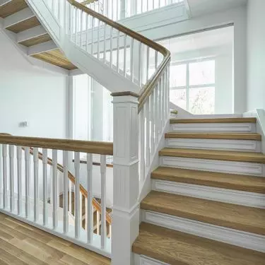 Closed cheek staircase with treads. Steps and handrails made of oiled oak. Cheeks, columns, balusters and treads made of ash painted with opaque paint. Balustrade columns, balusters milled. Realization private house