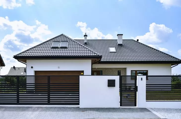 Front fence made of concrete blocks and plastered, including spans with spacing between profiles - from 2 to 4 cm