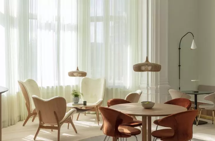 From left, A Conversation Piece and The Reader armchairs, Hang Out table, Time Flies chairs, Clava Dine Wood pendant lamp