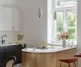 stylową złotą wyspę kuchenną oświetlają lampy marki Petite Friture