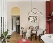 view of the dining room and the golden arch over the entrance to the hallway