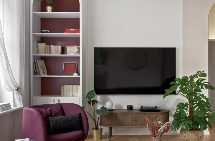 The arch in the bookcase by the TV relates to the golden arch above the entrance to the hallway