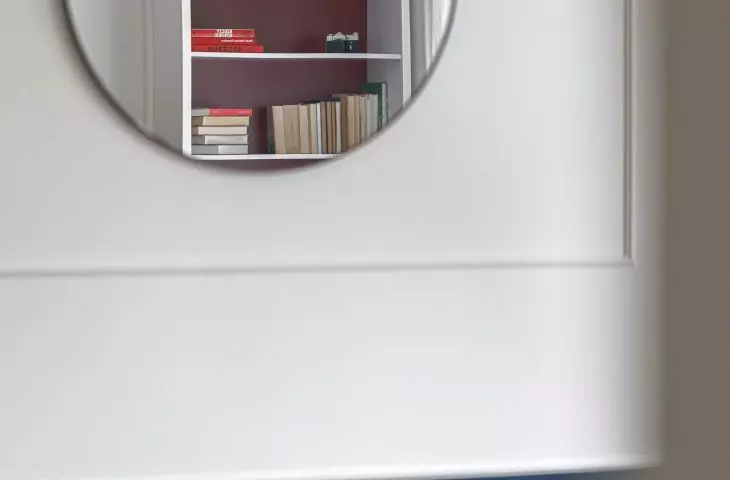 A round mirror in the living room optically enlarges the space