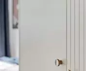 The milling on the cabinet refers to the lamellas appearing in the apartment