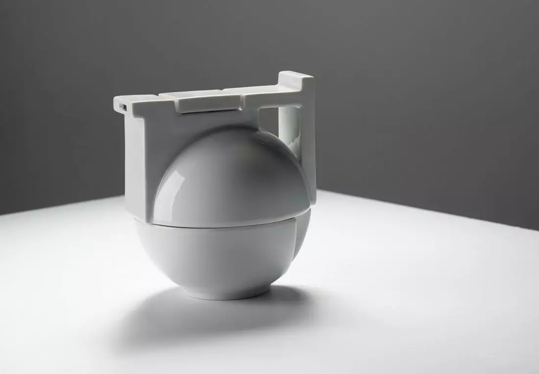 BAU — Zestaw do herbaty inspirowany geometrią Projekt Edyta Cieloch 2019 Czajnik i filiżanka jako jedna bryła, tworzą zwartą kompozycję przestrzenną. Forma zbudowana przez cięcie i łączenie podstawowych figur geometrycznych — kuli i prostopadłościanu odwołuje się do aktualnej również dzisiaj bauhausowskiej idei kompozycji prostych brył.