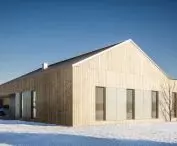 The facade is covered with larch board and architectural concrete panels