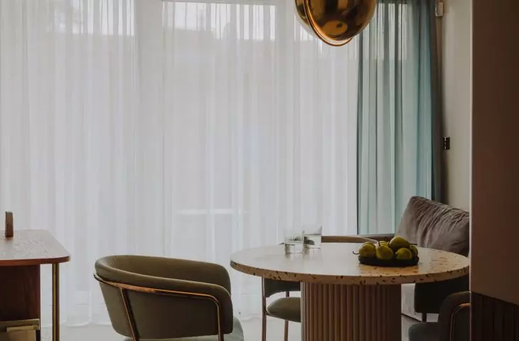 Above the table hangs a brass GUBI lamp, a 1972 design by Louis Weisdorf