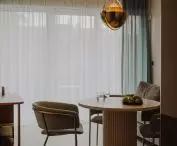 Above the table hangs a brass GUBI lamp, a 1972 design by Louis Weisdorf