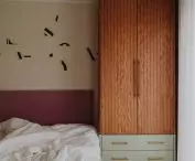 wooden closet and pink upholstered bed headboard