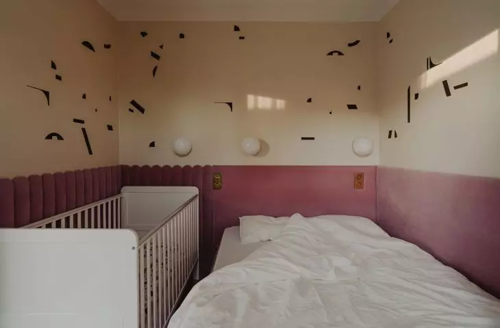 The decoration on the bedroom wall is reminiscent of beachgoers seen from a bird's eye view