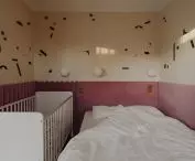 The decoration on the bedroom wall is reminiscent of beachgoers seen from a bird's eye view