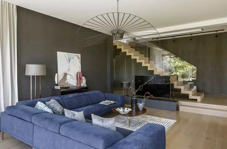 Granatowa sofa i wolnostojące schody