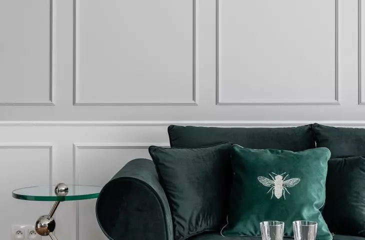 Sofa in bottle green color accompanied by decorative tables