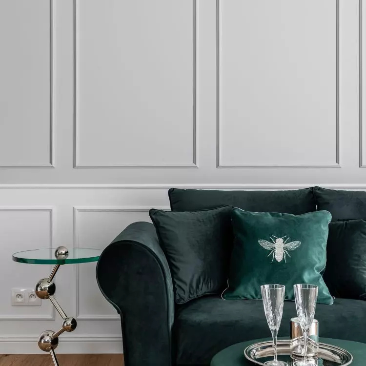 Sofa in bottle green color accompanied by decorative tables