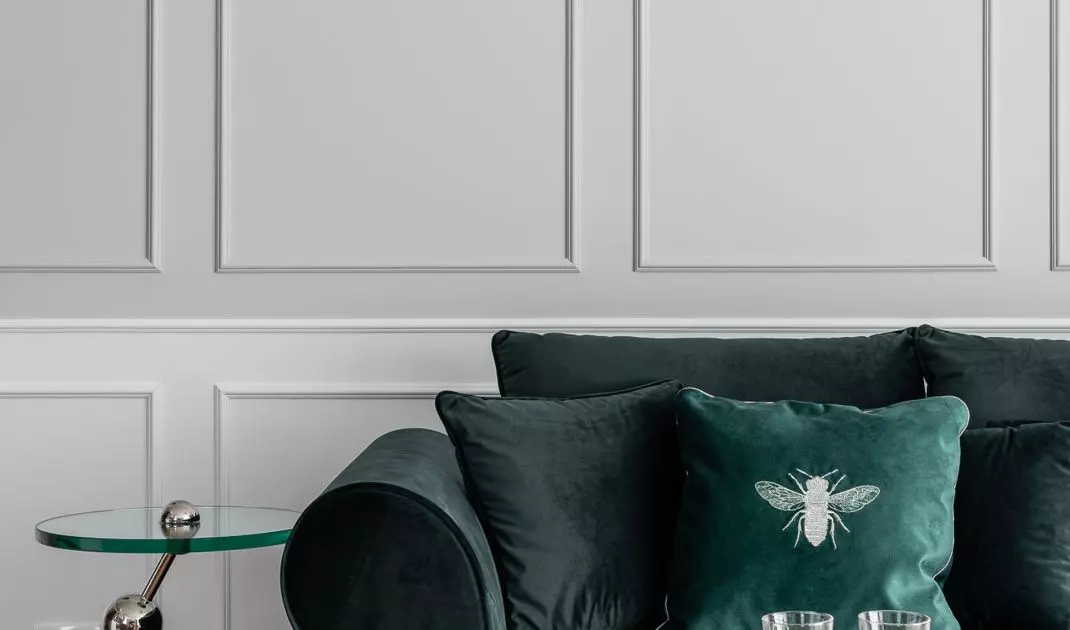 Sofa in bottle green color accompanied by decorative tables