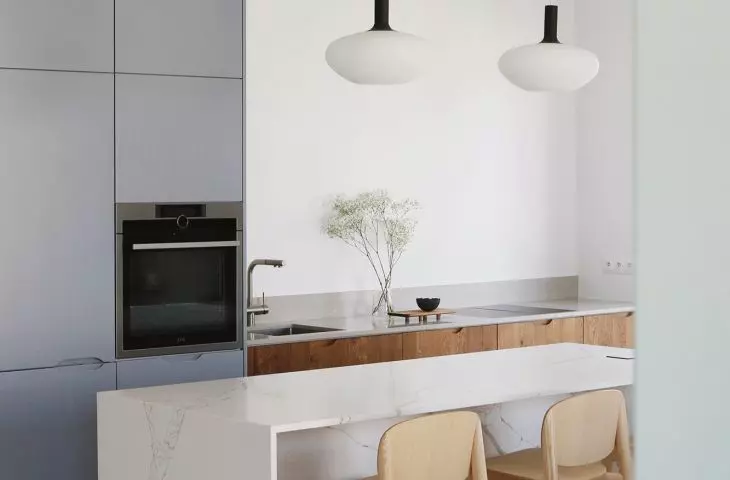 Kitchen with blue cabinetry and marble kitchen island