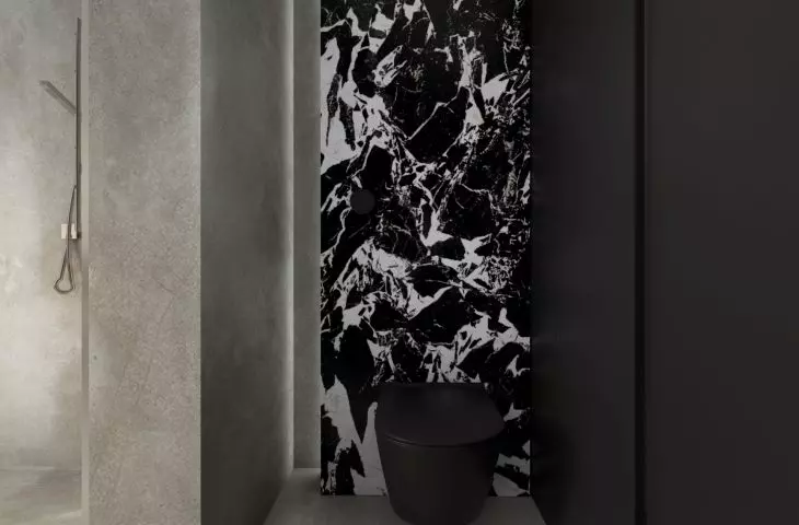 Separate toilet with patterned black and white wall