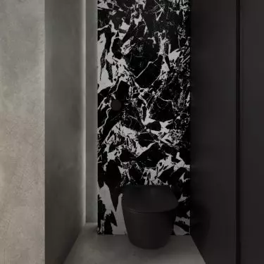 Separate toilet with patterned black and white wall