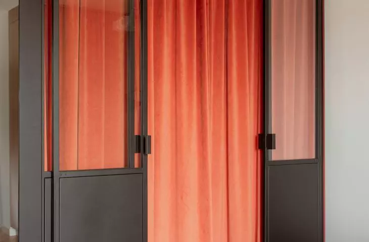 A bed is hidden behind a velour curtain