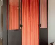 A bed is hidden behind a velour curtain