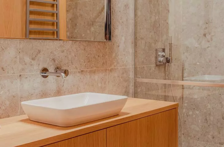 The bathroom also features a veneer and terrazzo motif