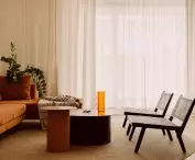 elementem, który przyciąga wzrok w części dziennej, jest sporych rozmiarów sofa w rudym kolorze