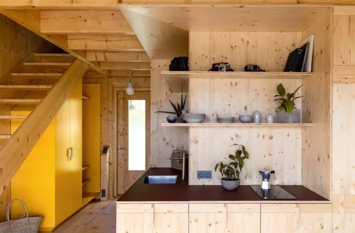 The interior is finished with wood, and a yellow cabinet at the entrance adds an accent