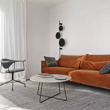 A strong color accent in the living room is the red sofa