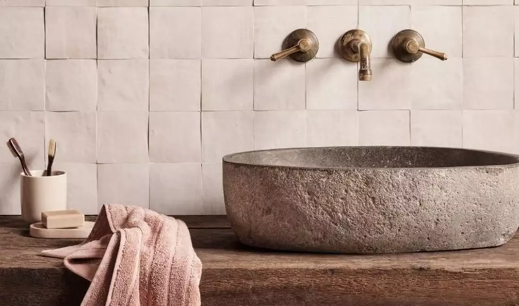 Stone washbasin on wooden countertop