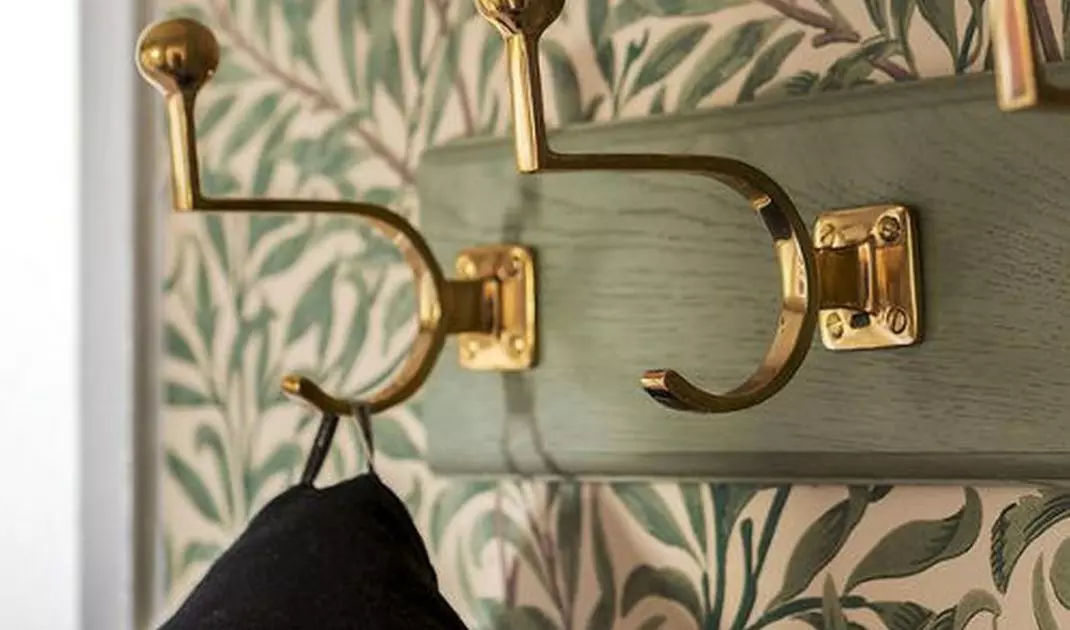 Watercolor wallpaper as background of hangers in the hallway