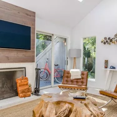 Placing the TV against a background of wood and near the fireplace will warm up the interior 