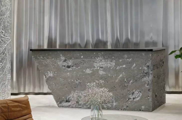 The reception area of the hair salon is behind a countertop of crushed, porous concrete