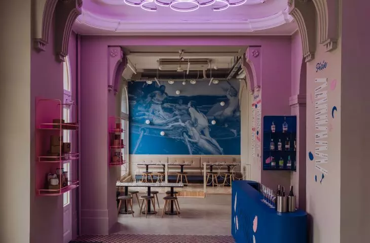 two walls are covered with wallpaper depicting a fragment of Herbert James Draper's painting 