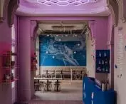 two walls are covered with wallpaper depicting a fragment of Herbert James Draper's painting 
