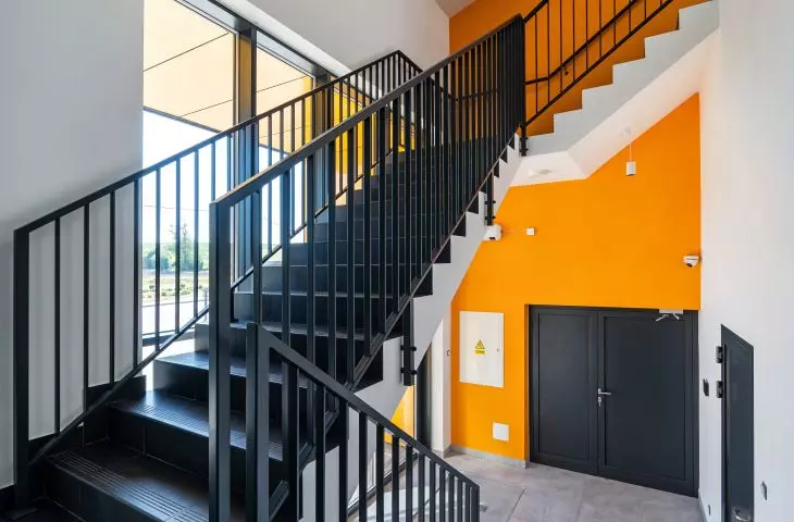 The color scheme of the staircase refers to the facade of the building