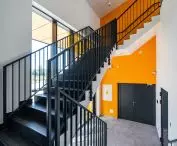 The color scheme of the staircase refers to the facade of the building