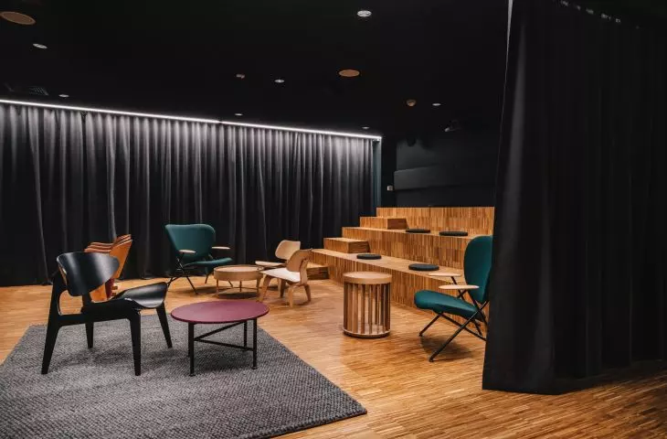 Sala kinowa z drewnianymi stopniami tworzącymi widownię